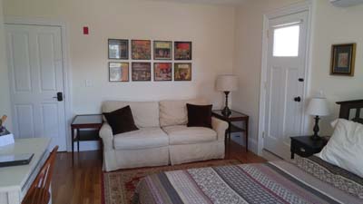 sleeper loveseat, endtables, vinyl album covers framed and hung on wall